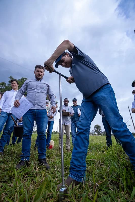 Aluno usando o trado para tirar a amostra de terra
